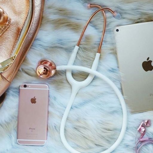 Flat lay of tech gadgets on a fur rug, including a phone, tablet, headphones, and a makeup bag