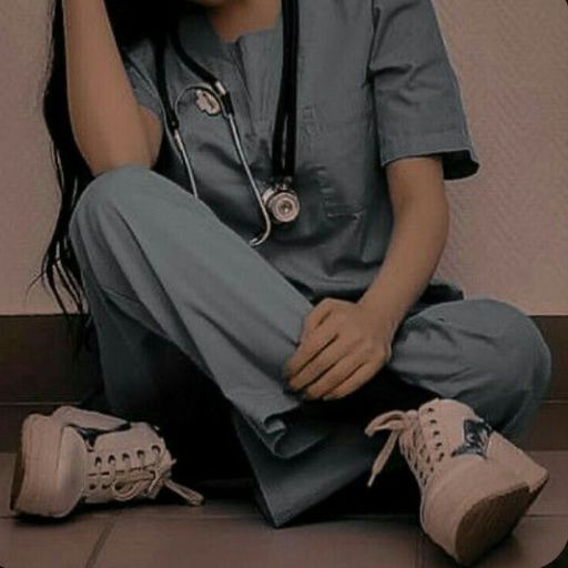 Person in scrubs sitting with a stethoscope, sneakers visible