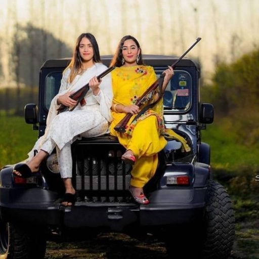 Two people sitting on the back of a jeep holding musical instruments